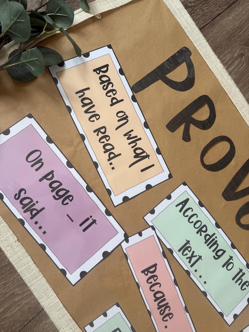 May include: A brown poster with the word "PROVE" in large black letters. Several rectangular cards with black polka dots and text like "Based on what I have read..." and "On page - it said..." are arranged on the poster.