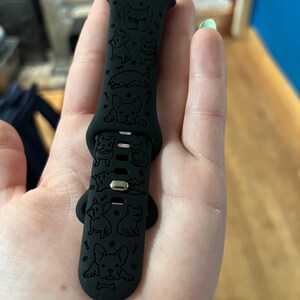 May include: Black silicone Apple Watch band with a repeating pattern of French Bulldog silhouettes and bone designs.