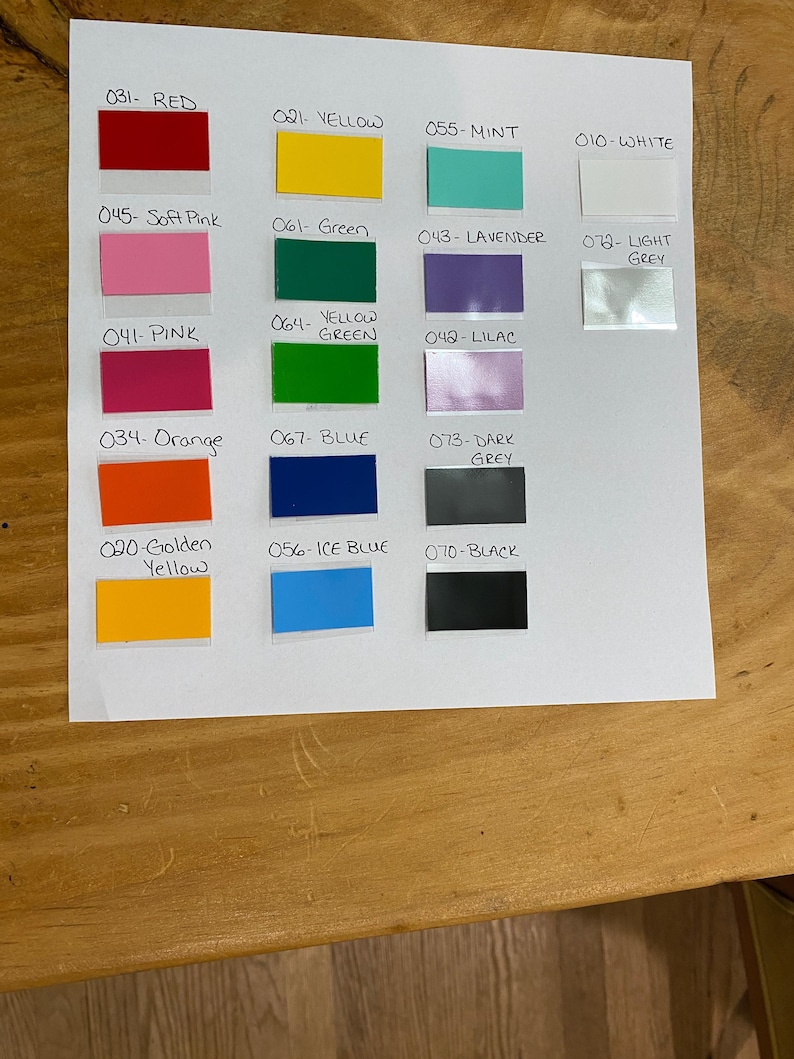 May include: A color chart featuring rectangular swatches in various hues, including red, yellow, green, blue, pink, and grey. Each swatch is labeled with a number and color name, such as "031- RED" and "070- BLACK".