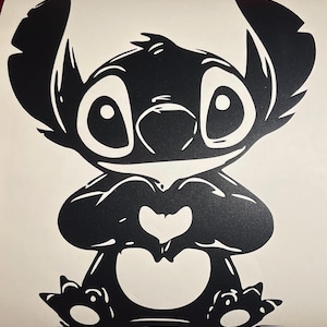 May include: Black and white cartoon illustration of a character with large eyes, ears, and a heart-shaped gesture with its hands. The character is sitting with its feet forward. The image is a simple, graphic design.