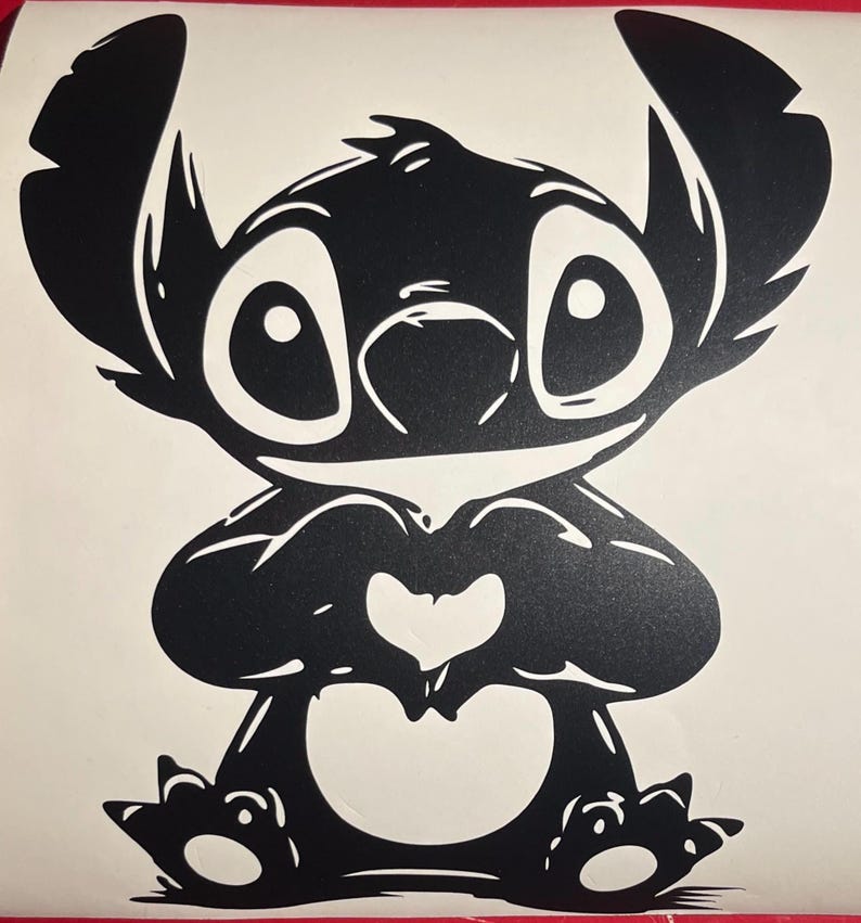 May include: Black and white cartoon illustration of a character with large eyes, ears, and a heart-shaped gesture with its hands. The character is sitting with its feet forward. The image is a simple, graphic design.