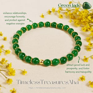 Könnte beinhalten: Ein grünes Jade-Armband mit goldfarbenen Perlen und Akzenten. Das Armband wird auf einer cremefarbenen Oberfläche mit gelben Blumen präsentiert. Der Text "Green Jade" und "Timeless TreasuresAha" ist sichtbar.