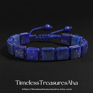 May include: A blue square stone bracelet with gold flecks. The bracelet is made of square lapis lazuli stones strung together with blue cord. The bracelet has an adjustable sliding knot closure. The text "Timeless Treasures Aha" is at the bottom.