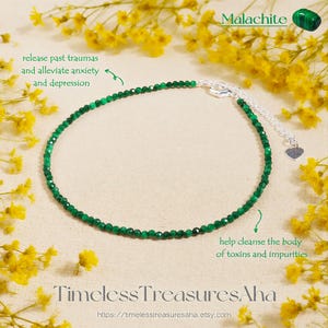 May include: A delicate green malachite beaded bracelet with a silver clasp and heart charm. The image includes text that reads "Malachite" and "Timeless TreasuresAha". The bracelet is surrounded by yellow flowers.