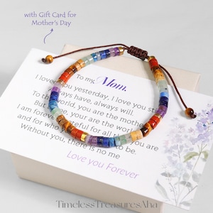 Puede incluir: Una pulsera de cuentas coloridas con una variedad de piedras preciosas, dispuestas en un patrón de arcoíris. La pulsera está sobre una tarjeta blanca con el texto "To my Mom. Love you Forever." La tarjeta está dentro de una caja blanca.