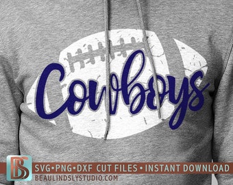 May include: A white football with a distressed texture and the word "Cowboys" written in blue cursive lettering.