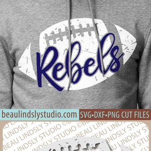 May include: A white football with a distressed, vintage look. The word "Rebels" is written in blue cursive across the football. The football is on a gray background.