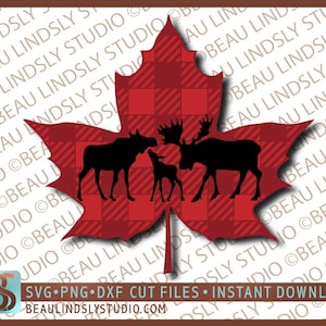 May include: A red and black plaid maple leaf with a silhouette of a moose and two fawns inside. The maple leaf is a symbol of Canada.
