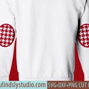 以下が含まれることがあります： 袖に赤い千鳥格子模様の円がついた白い長袖スウェットシャツ。画像の下部に「beaulindslystudio.com SVG.DXF.PNG CUT FILES」というテキストがあります。