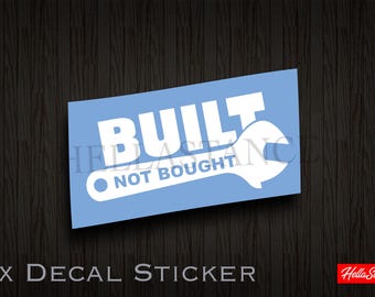 Könnte beinhalten: Blauer Aufkleber mit weißem Text "BUILT NOT BOUGHT" und einer Schraubenschlüsselgrafik.