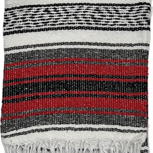 May include: A woven blanket with a striped pattern in red, black, white, and gray. The blanket has a fringe along one edge. The design features alternating bands of color, creating a textured appearance. This blanket is suitable for various uses.