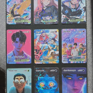 May include: Nine trading cards featuring anime-style characters. Each card has a unique illustration, character name, and numerical values. The cards are in a protective sleeve, with the top card labeled "Rumi".
