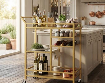 May include: A gold-toned metal rolling bar cart featuring multiple shelves, a handle, and four caster wheels. The cart holds various glass bottles, a wooden knife block, a mortar and pestle, a basket of garlic, spice jars, wine bottles, and bowls.