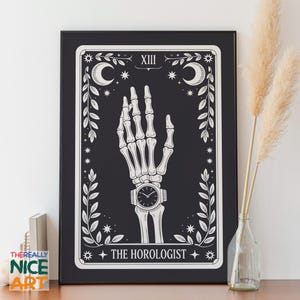 Può includere: Stampa artistica con cornice nera con una mano scheletrica che indossa un orologio. Il design include lune crescenti, stelle ed elementi botanici. Il testo recita "XIII" e "THE HOROLOGIST" in bianco.