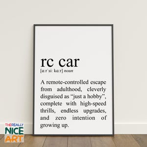May include: A framed print featuring the text "rc car" and its phonetic pronunciation, followed by a humorous definition. The definition describes an rc car as an escape from adulthood, disguised as a hobby.