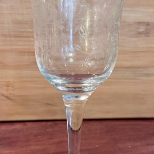 May include: A white ceramic mug with a black handle and the text "But First, Coffee" in a bold, black font. The mug is set against a neutral background, highlighting its simple design.