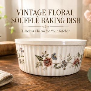 May include: A white ceramic soufflé baking dish with vertical fluted sides and a colorful floral pattern featuring red, blue, and green botanical motifs. The dish is round with a smooth rim and a textured exterior surface, showcasing a classic design.