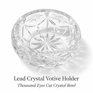 May include: A white ceramic mug with a black handle and the text "But First, Coffee" in a bold, black font. The mug is set against a blurred background, suggesting a cozy setting.