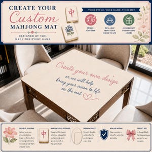 May include: A custom mahjong mat featuring a cream-colored surface with the text 'Create your own design or we will help bring your vision to life on the mat' in pink and blue script. The mat is displayed on a wooden table with four chairs.