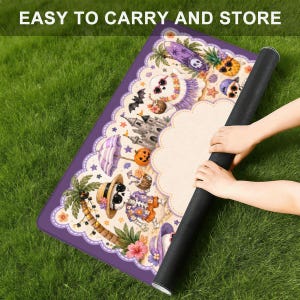 May include: A rectangular purple mat featuring a tropical Halloween illustration with skeletons, a sandcastle, pumpkins, and palm trees. The text EASY TO CARRY AND STORE is printed at the top. The mat has a scalloped white border and a black underside.