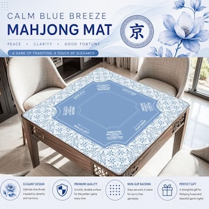 May include: A blue Mahjong mat with a floral design, featuring text that reads "Calm Blue Breeze Mahjong Mat." The mat is on a wooden table. The mat has a central playing area and text indicating game play.