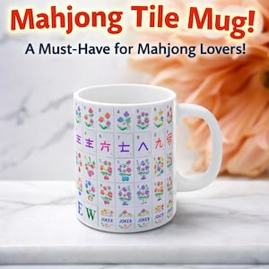 May include: White ceramic mug featuring a colorful Mahjong tile design with floral and number patterns. The mug has a white handle and the text "Mahjong Tile Mug! A Must-Have for Mahjong Lovers!" is displayed at the top.