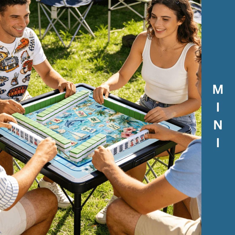 Puede incluir: Un grupo de personas jugando al Mahjong en una mesa port&aacute;til. La mesa tiene un dise&ntilde;o floral azul y blanco con fichas verdes y blancas. La palabra "MINI" est&aacute; impresa verticalmente en el lateral.