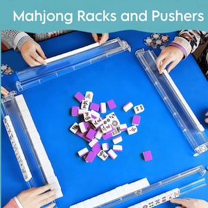 May include: A blue table with clear plastic Mahjong racks and pushers. The game pieces are purple and white. The text "Mahjong Racks and Pushers" is at the top of the image. Several hands are visible, interacting with the game.