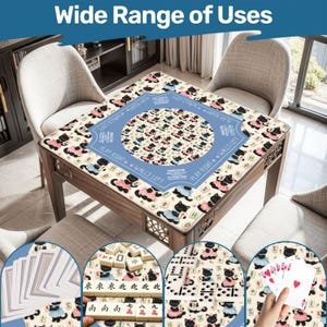 May include: A wooden game table with a patterned surface featuring black cats in pink and blue dresses. The table has a blue circular design in the center with text. The image shows various game pieces, including cards, dominoes, and mahjong tiles.
