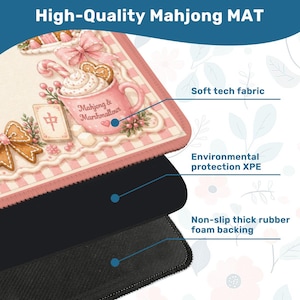 May include: A high-quality Mahjong mat with a pink and white design featuring a teacup with marshmallows and gingerbread cookies. The mat has a soft tech fabric, environmental protection XPE, and a non-slip thick rubber foam backing. The text "High-Quality Mahjong MAT" is at the top.