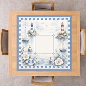 May include: A square tablecloth featuring a nautical theme with lighthouses, sailboats, lifebuoys, and white flowers. The design includes a central blank rectangular frame bordered by a rope pattern and a blue and white checkered outer border.