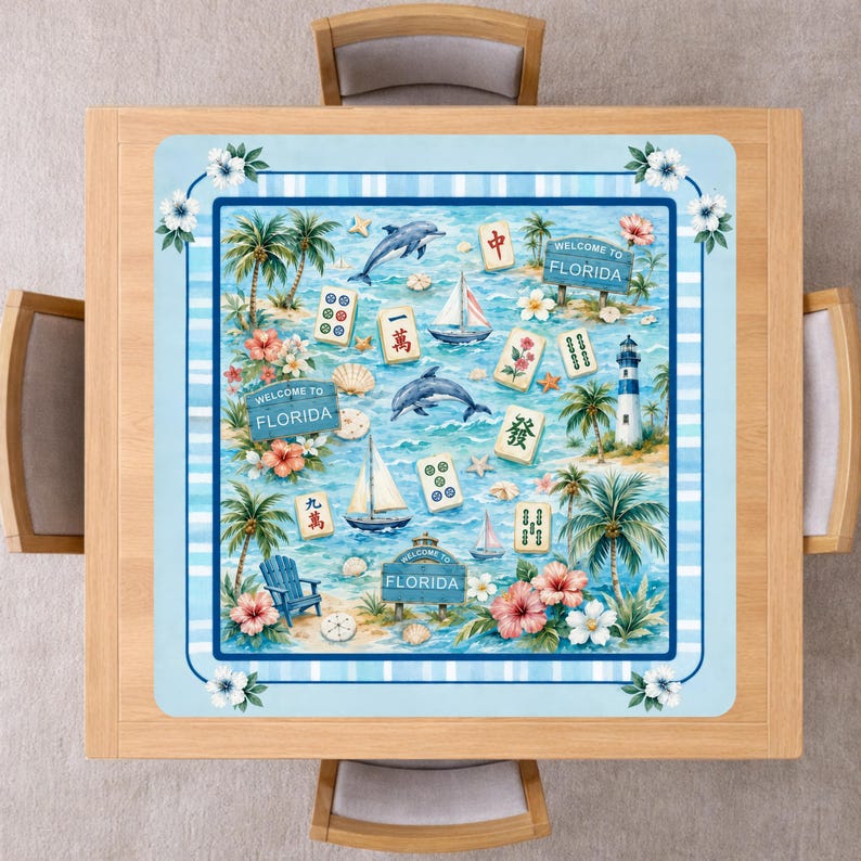 Puede incluir: Un mantel cuadrado con un tema de Florida. El dise&ntilde;o presenta palmeras, delfines, veleros y fichas de Mahjong. Las palabras "WELCOME TO FLORIDA" se muestran en letreros. El borde es azul claro con flores blancas.