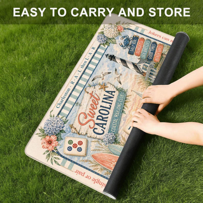 May include: A rectangular mahjong mat featuring a coastal theme with a lighthouse, surfboards, and floral accents. The text reads Sweet Carolina Coastal Mahjong Club, Charleston, and various beach-themed signs. The mat has a black underside.