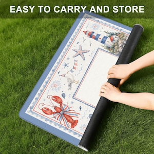 May include: A rolled-up black mat with a nautical design featuring a lighthouse, starfish, and lobster. The mat is on a blue border and the text "EASY TO CARRY AND STORE" is visible.