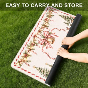 Puede incluir: Una alfombra rectangular con un dise&ntilde;o navide&ntilde;o festivo que incluye un gran lazo a rayas rojas y blancas, una campana dorada, bastones de caramelo, ramas de pino y bayas de acebo sobre un fondo crema. Texto: EASY TO CARRY AND STORE.
