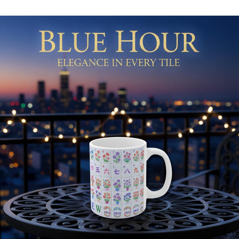 May include: White ceramic mug with a colorful floral and number design, with the text "BLUE HOUR" and "ELEGANCE IN EVERY TILE". The mug is on a black metal table with a city skyline in the background.