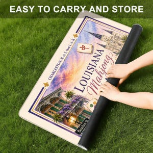 Puede incluir: Una alfombrilla rectangular con una ilustraci&oacute;n colorida de un edificio de Luisiana, una ficha de mahjong y el texto "LOUISIANA Mahjong" y "CHARLESTON-R-A-L then L-A-R". La alfombrilla tiene un borde oscuro y est&aacute; parcialmente enrollada.