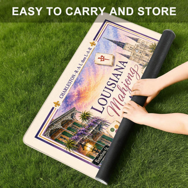 Puede incluir: Una alfombrilla rectangular con una ilustraci&oacute;n colorida de un edificio de Luisiana, una ficha de mahjong y el texto "LOUISIANA Mahjong" y "CHARLESTON-R-A-L then L-A-R". La alfombrilla tiene un borde oscuro y est&aacute; parcialmente enrollada.