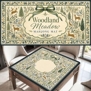 May include: A rectangular mahjong mat featuring a cream-colored center with a green ribbon bow and the text Woodland Meadow MAHJONG MAT. The border displays a woodland scene with deer, trees, and floral patterns in shades of green and blue.