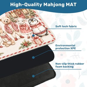 Puede incluir: Una alfombrilla de Mahjong rectangular con una ilustraci&oacute;n navide&ntilde;a de un oso, un cordero y un ping&uuml;ino con ropa de invierno. La alfombrilla consta de una capa superior de tela t&eacute;cnica suave, una capa intermedia de XPE y una base de espuma de caucho antideslizante.