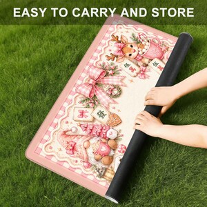 May include: A rectangular mat featuring a pink and white gingham border and a festive illustration of a reindeer and a gnome with holiday decorations, including bows, gifts, and gingerbread cookies. The text "EASY TO CARRY AND STORE" is visible.