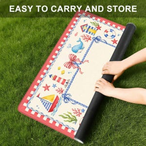 May include: A rolled-up, rectangular mat with a nautical theme, featuring a red and white border. The mat's design includes a lighthouse, sailboat, whale, and other sea-related illustrations. The text "EASY TO CARRY AND STORE" is visible at the top.
