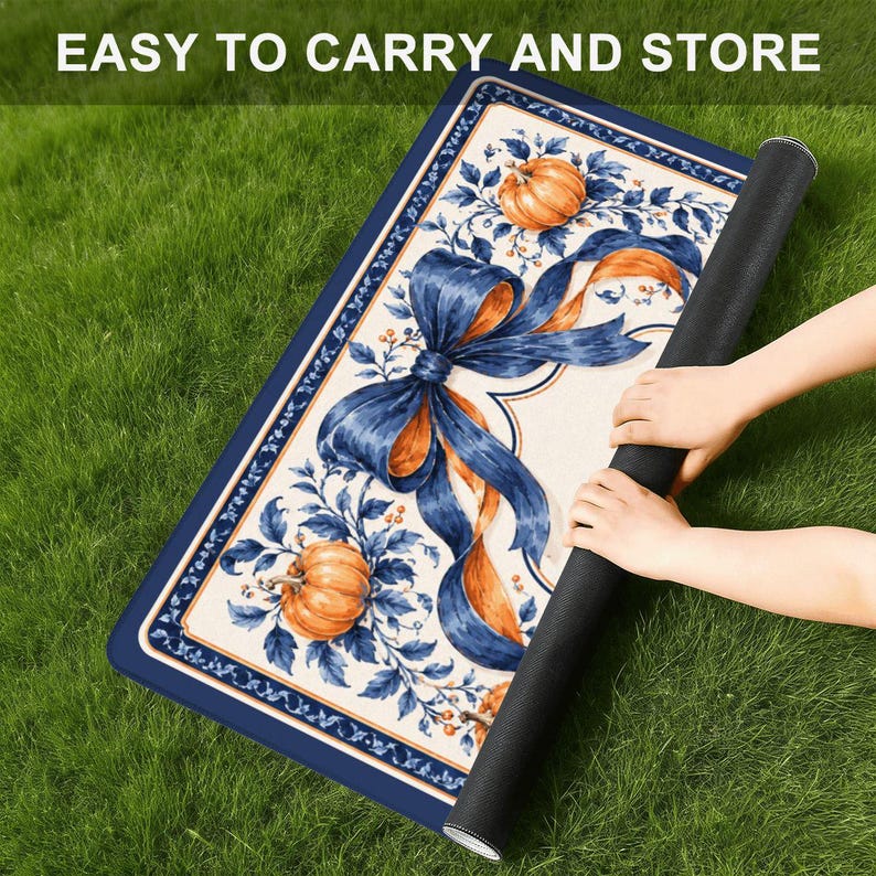 May include: A rectangular mat featuring a cream-colored center with a large blue ribbon bow, orange pumpkins, and blue foliage. The border is dark blue with a thin orange line. The text EASY TO CARRY AND STORE is printed at the top.