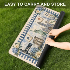 May include: A rolled-up rectangular mat featuring a New York City skyline, floral accents, and Mahjong tiles. The mat has a blue and white striped border and the text "EASY TO CARRY AND STORE".