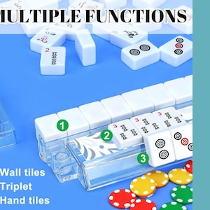 May include: A close-up of a Mahjong set with white tiles and colorful chips on a blue surface. The text "MULTIPLE FUNCTIONS" is at the top. The image highlights the wall tiles, triplets, and hand tiles.