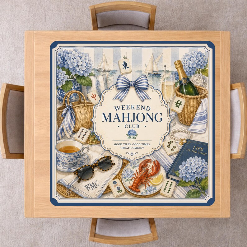 May include: A square wooden table with a blue and white Weekend Mahjong Club design. The design includes a bow, flowers, sailboats, and various Mahjong game elements. The table is surrounded by four wooden chairs.
