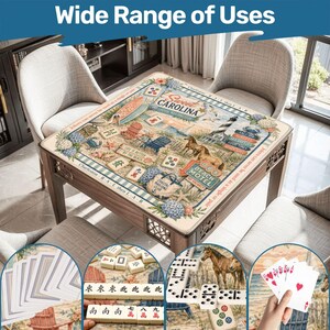 May include: A square mahjong table featuring a coastal-themed mat with illustrations of a lighthouse, horses, beach chairs, and the text Sweet Carolina Coastal Mahjong Club, accompanied by mahjong tiles, playing cards, and dominoes.