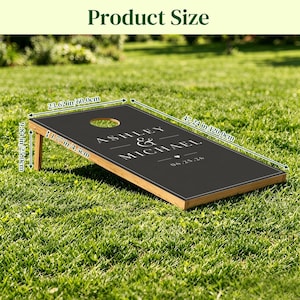 May include: A black cornhole board with a light wood frame, featuring the white text ASHLEY & MICHAEL and the date 06.25.26. Dimensions are 47.24 inches long, 23.62 inches wide, 9.84 inches high, and 1.77 inches thick for the board frame.