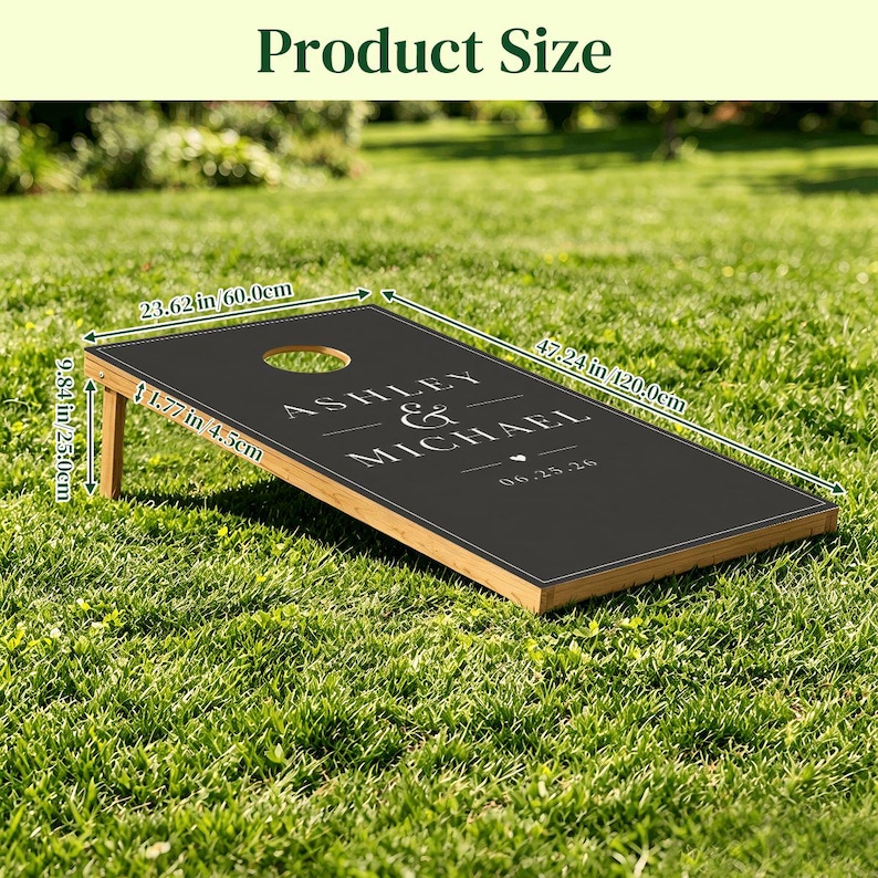May include: A black cornhole board with a light wood frame, featuring the white text ASHLEY & MICHAEL and the date 06.25.26. Dimensions are 47.24 inches long, 23.62 inches wide, 9.84 inches high, and 1.77 inches thick for the board frame.