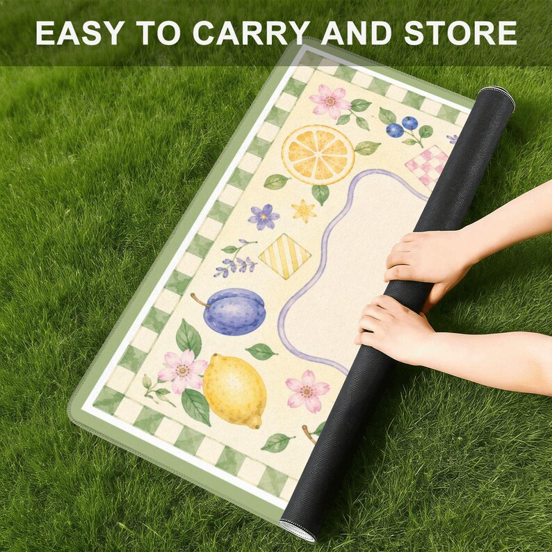 May include: A rectangular mat featuring a cream-colored surface with a green and white checkered border. The design includes illustrations of a yellow lemon, a purple plum, orange slices, blue berries, and pink flowers. The text reads EASY TO CARRY AND STORE.